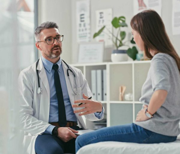 Shot of a mature doctor sitting with his patient in the clinic and asking questions during a consultation I get really bad tummy cramps
