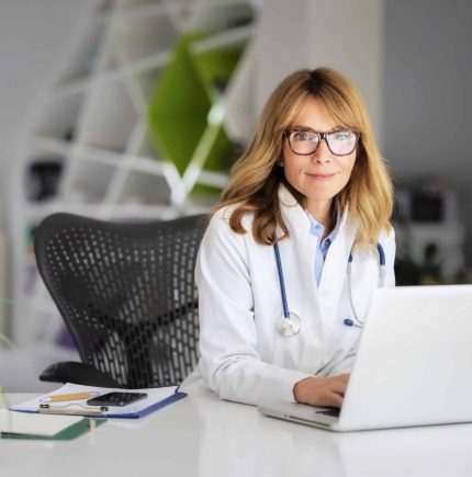 Cropped shot of an attractive female doctor using laptop for work at hospital Smiling female healthcare worker using laptop and working in doctorâs room.